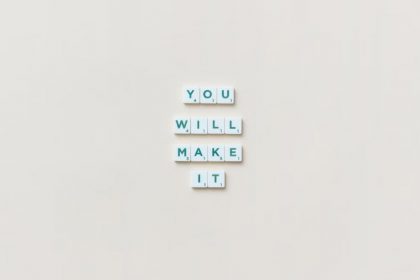 Motivational phrase 'You Will Make It' made from Scrabble tiles on a neutral background.